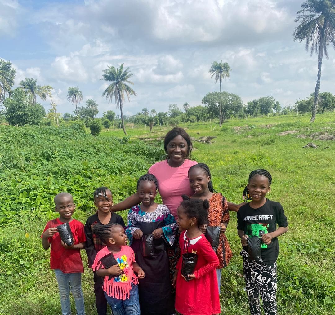 Mariam with children holding seedlings on the farm